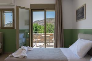 a bedroom with a bed and a view of a patio at Anopoli Rooms in Sinoikismós Kámbos