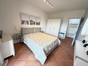 a bedroom with a bed and a tiled floor at Residence Virgilio in Sirmione