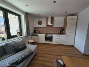 a living room with a couch and a kitchen at Tante Maridi in Forstau