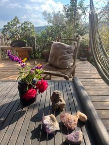a hammock with rocks and a chair on a deck at Meek Yurt in Yodefat
