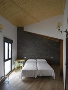 1 dormitorio con 1 cama con pared de ladrillo en Apartamentos La Rocanda, en Coca