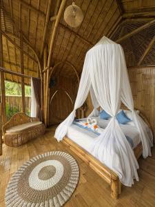 a bedroom with a bed with mosquito nets at Bamboo Garden Villa Sidemen - Private Pool & Nature View in Selat