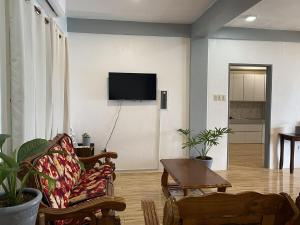 a living room with a couch and a tv on a wall at Beachfront Sunset Getaway in Allen