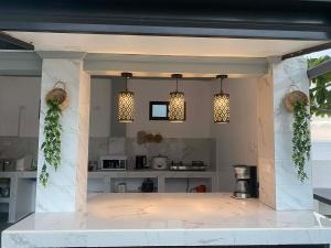 a kitchen with two pendant lights and a counter at Beachfront Sunset Getaway in Allen