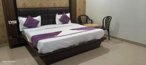 a bedroom with a large bed with purple pillows at Hotel Grand Inn in Lucknow