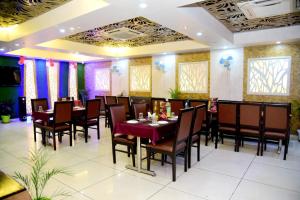 a dining room with a table and chairs at Hotel Grand Inn in Lucknow