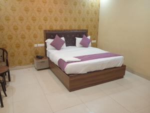 a bedroom with a large bed with purple pillows at Hotel Grand Inn in Lucknow