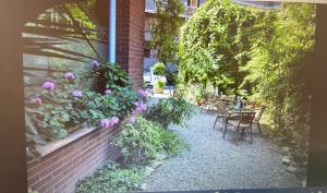 a garden with tables and chairs and flowers on the side of a building at Hotel Cosmos Tarragona in Tarragona