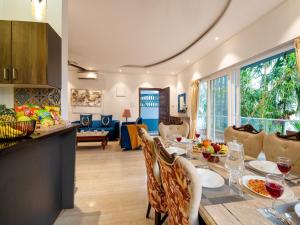 a kitchen and living room with a table and chairs at DanCenter Infinity Villa I 5BHK I Pvt Pool I Baga I GOA in Goa