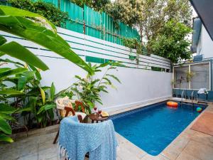 a swimming pool in the middle of a yard with plants at DanCenter Infinity Villa I 5BHK I Pvt Pool I Baga I GOA in Goa