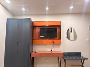 a room with a desk and a tv and a cabinet at Farm Shaala in Tiruttani