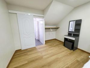 a room with a white door and a television at M-Well House in Sathani Ban Hua Mak