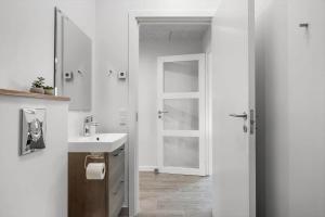 a white bathroom with a sink and a mirror at FY396-Middelfart-Siriusvej-4 in Middelfart +23 photos