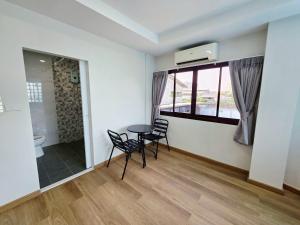 a room with a table and chairs and a bathroom at M-Well House in Sathani Ban Hua Mak