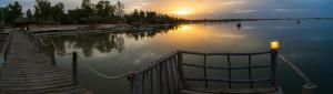 a body of water with a dock and a sunset at Mar Setal in Mar Lodj