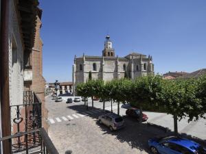 an old building with cars parked in front of it at Apartamentos La Rocanda in Coca
