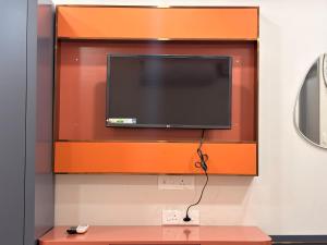 a flat screen tv hanging on a wall at Farm Shaala in Tiruttani