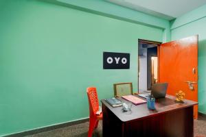 an office with a desk with a laptop and a red door at Hotel O White Inn in Chennai