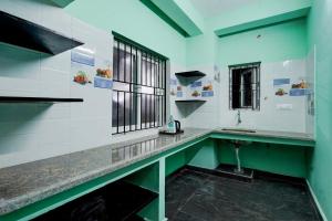 a bathroom with a counter with a sink and a window at Hotel O White Inn in Chennai