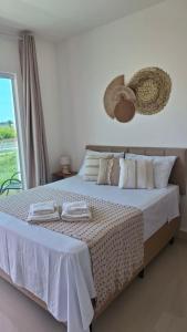 a bedroom with a bed with two towels on it at La casa de Luna in Guaibim