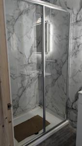 a shower with a glass door in a bathroom at Polbarrow in Ruan Minor