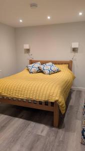 a bed with yellow sheets and pillows on it at Polbarrow in Ruan Minor