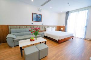 a hotel room with a bed and a couch at Thời đại Hotel in Thanh Hóa