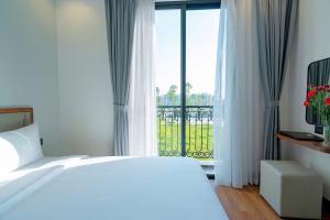 a bedroom with a bed and a window with a balcony at Thời đại Hotel in Thanh Hóa