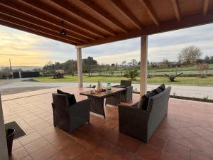 a patio with a table and chairs and a view of a field at Refugio y Calma in Chantada