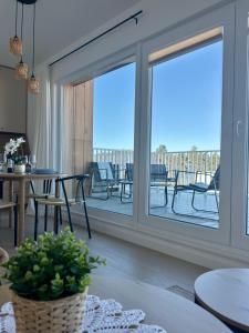 a living room with sliding glass doors and a patio at Let's Sea Positive Vibe apartment in Gąski