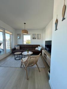 a living room with a couch and a table at Let's Sea Positive Vibe apartment in Gąski