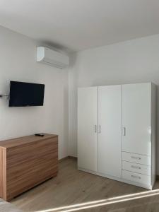 a bedroom with white cabinets and a tv on the wall at Antico Ticino Malpensa in Lonate Pozzolo +42 photos