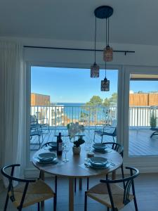 a dining room with a table and chairs and a balcony at Let's Sea Positive Vibe apartment in Gąski