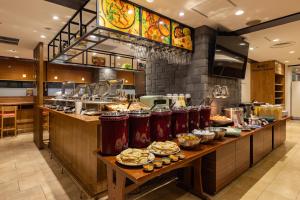a buffet line in a restaurant with food on it at Hotel Keihan Tenmabashi in Osaka