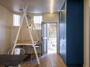 a room with a ladder and a table and chairs at ibis Styles Asnieres Centre in Asnières-sur-Seine