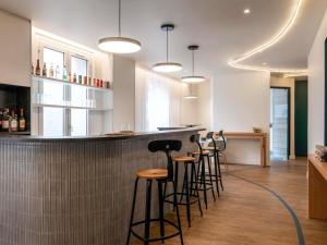 a bar with a row of stools in a room at ibis Styles Asnieres Centre in Asnières-sur-Seine