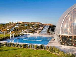 an elliptical building with a swimming pool and an observatory at ibis Styles Saint Julien en Genevois accès espace aquatique UCPA Vitam INCLUS in Neydens
