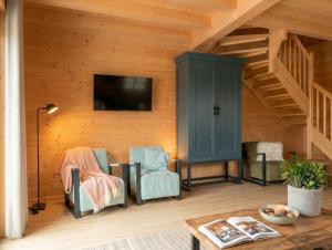 a living room with two chairs and a tv at Chalet Rattendorf 139 in Rattendorf