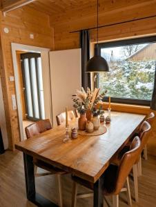 a dining room table with chairs and a large window at Chalet Rattendorf 139 in Rattendorf