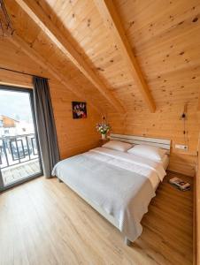 a bed in a wooden room with a large window at Chalet Rattendorf 139 in Rattendorf