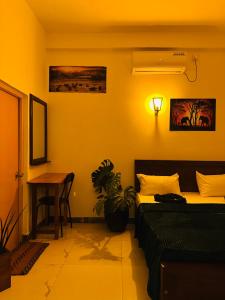 a bedroom with a bed and a table and a desk at Jaya Villa - Near Airport in Negombo