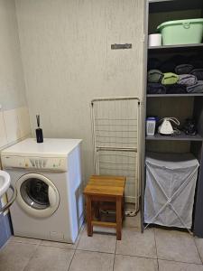 a laundry room with a washing machine and a table at Līgatne Forest View Apartament in Skalupji