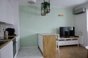 a kitchen with a counter top and a tv at APARTAMENT PRZYSTAŃ in Giżycko +3 photos