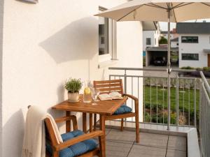 a table and chairs on a balcony with an umbrella at Ferienwohnung Elena in Tettnang