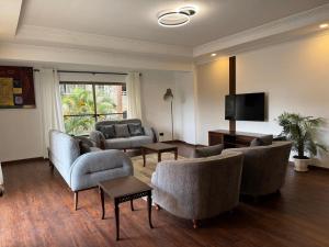 a living room with furniture and a flat screen tv at Eldon Hotel & Apartments in Nairobi