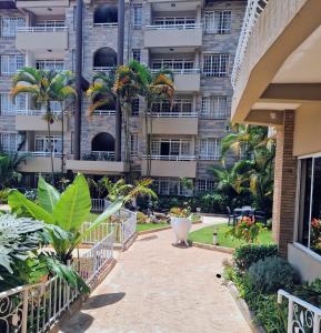 a walkway in front of a building with palm trees at Eldon Hotel & Apartments in Nairobi
