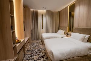 a hotel room with two beds and a mirror at Aurion AsSalaam Hotel Apartment in Medina +55 photos