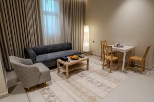 a living room with a couch and a table at Aurion AsSalaam Hotel Apartment in Medina