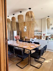 a table in a kitchen with chairs around it at Villa Le Cygne in Wimereux