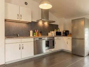 a kitchen with white cabinets and a stainless steel refrigerator at Ferienwohnung Elena in Tettnang